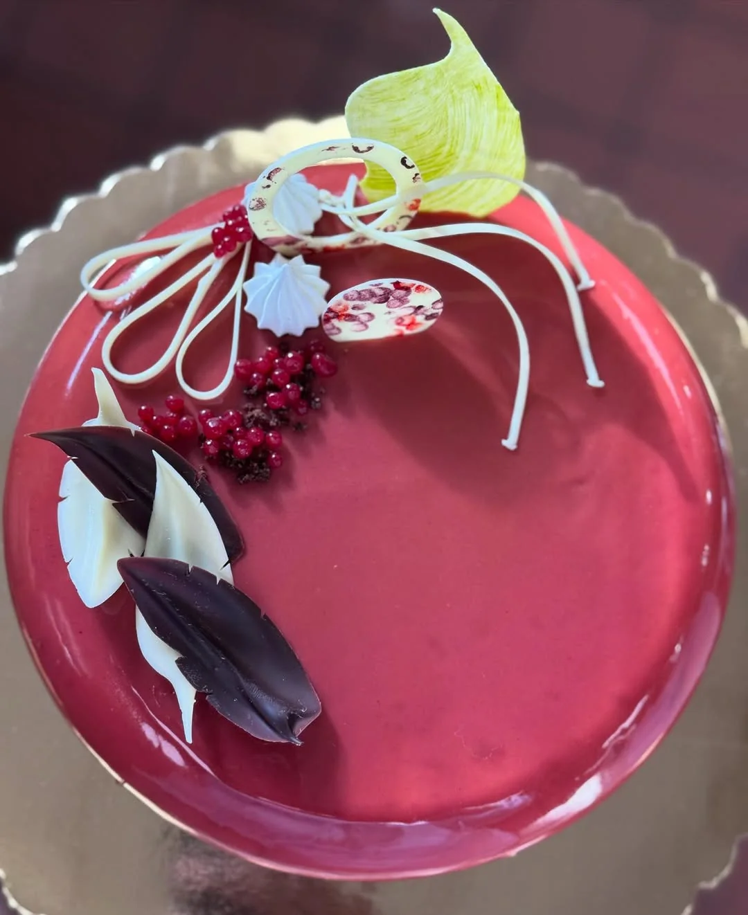 Cassis & Mirror — blackcurrant mousse beneath a glass-clear mirror glaze with cocoa-butter quenelles